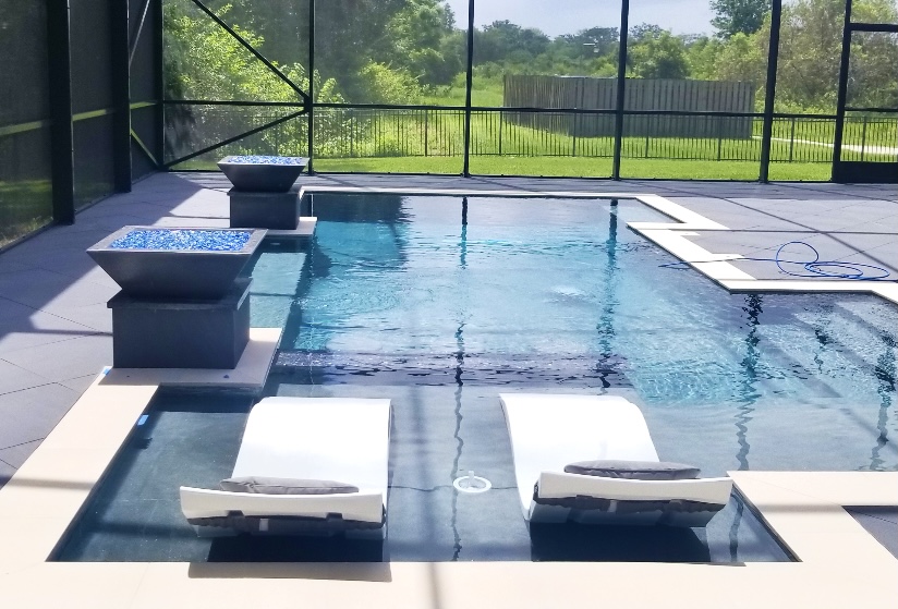 Modern Swimming Pool with ledge loungers and fire bowls Seffner