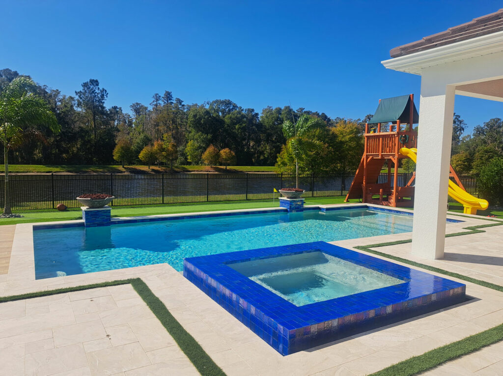 Odessa FL rectangular pool with raised tiled spa and turf